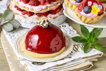 Chocolate cake with red fruit icing. Party table, various cakes
