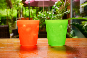 two plastic glass with straw on wooden background