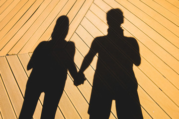 Couple holding hand in a shadow
