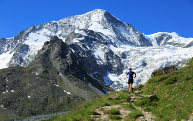 Fototapeta na wymiar Athlete trail running in the beautiful mountains of Arolla, Switzerland. Sports and healthy lifestyle concept.