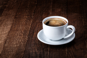 white mug of coffee on a wooden background