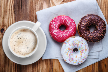white mug grain coffee and donuts on a wooden background