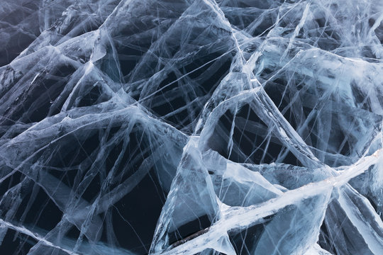 Natural background of ice. The mesh structure of cracks on the frozen Lake Baikal