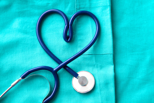 stethoscope shaping  heart and  clipboard on  medical uniform, closeup
