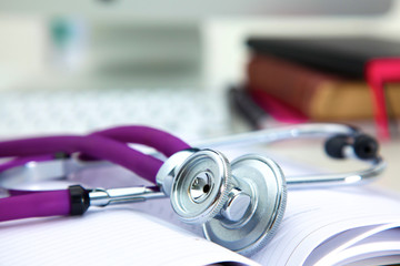 Stethoscope lying on a table  an open book