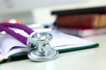 Stethoscope lying on a table  an open book