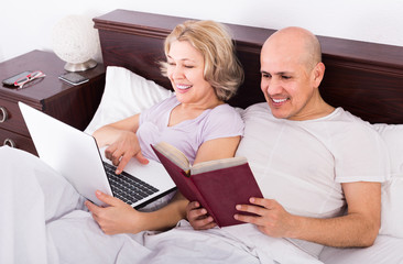adults together reading news from notebook and smartphone  in be