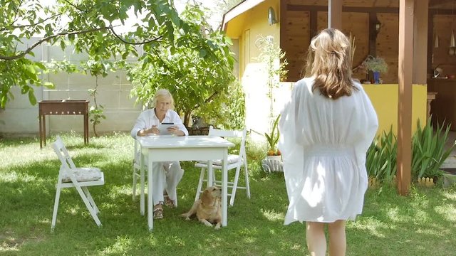 Woman sitting with a tablet outside in the garden.