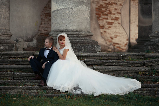 The lovely couple in love stand near coloums
