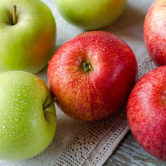 Red and green apples with drops of dew.