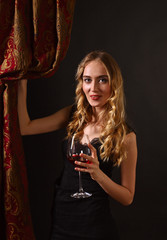 Fototapety  piękna blondynka w czarnej sukience z lampką czerwonego wina