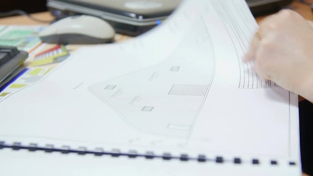 Girl leafing through a designer drawings projects.