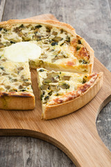 French quiche with vegetables on a rustic wooden table

