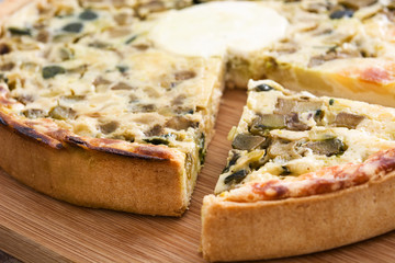 French quiche with vegetables on a rustic wooden table


