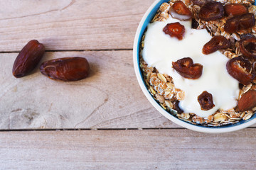 Top view of healthy Muesli bowl with wholegrain, oats, nuts and date fruit with yogurt