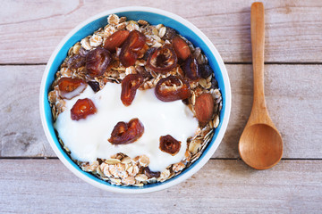 Top view of healthy Muesli bowl with wholegrain, oats, nuts and date fruit with yogurt