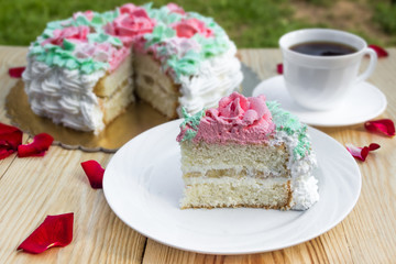 Piece of sponge cake  with curd cream  and banana on  background of cake and cup of coffee