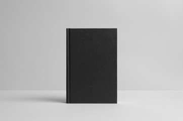 Black Hardcover Book Mock-Up - Front. Wall Background