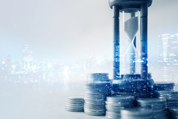 Double exposure of coin money and hourglass for about time of finance concept

