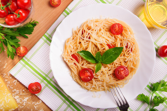 Spaghetti pasta with tomatoes and parsley on table. Top view