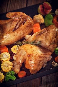 Roasted chicken with vegetables on baking plate