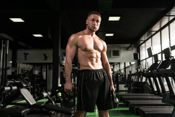 Fototapeta na wymiar Muscular Man Exercising With Kettle-bell