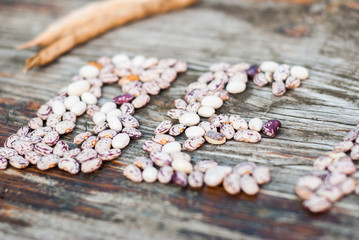The range of beans on wooden background, letters from