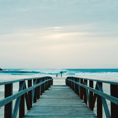 Fototapeta premium boardwalk and man taking a picture on the beach