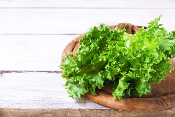 Close up of green oak lettuce on a wooden cutting board.