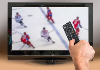 Man is watching hockey match on TV