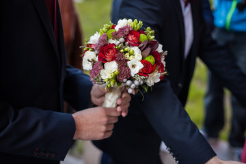 The groom keeps a wedding bouquet