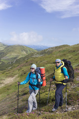 Summer hiking in the mountains with a backpack .