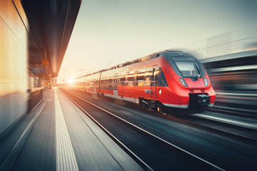 Fototapeta na wymiar Beautiful railway station with modern red commuter train at suns