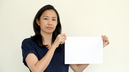 South East Asian girl casually holding while sign for copy space