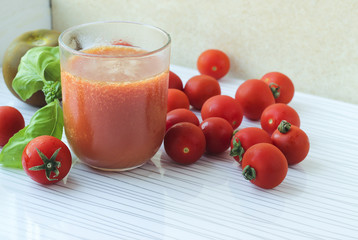 Glass of tomato juice on white background