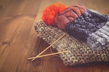 Fototapeta na wymiar knitting needles with wooly hat. winter cloth handemade