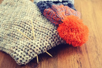 Fototapeta na wymiar knitting needles with wooly hat. winter cloth handemade