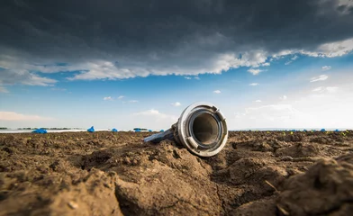 Tuinposter Dry land - drought - and hose for watering © Dusan Kostic