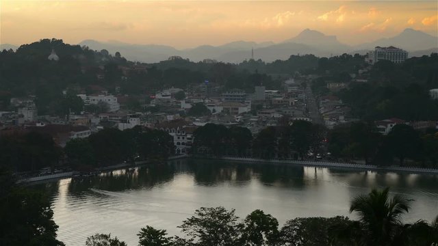 Lake in Kandy. Sunset over the former capital of Sri Lanka. Panoramic view at night with car light trails. Time-lapse