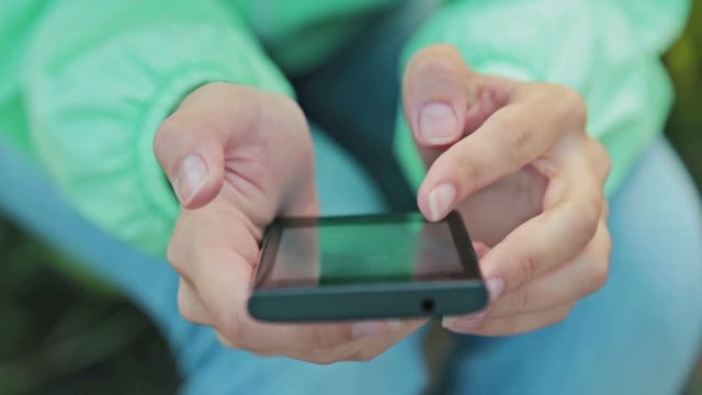 Close up of a woman using mobile smart phone outdoor