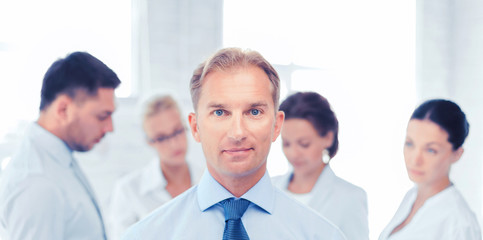 businessman in office with group on the back