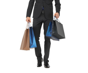 close up of man in suit with shopping bags