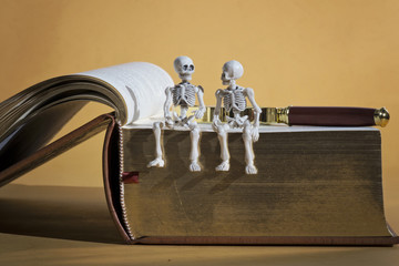 Skeletons, magnifying glass and a book