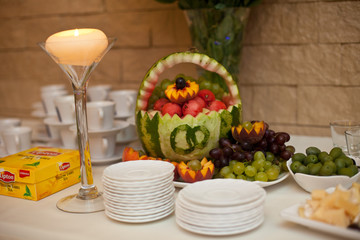 White plates stand in the front of originally served watermelon