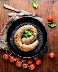 homemade sausages in a pan on a wooden background 