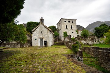 View to chapel and fortress ruins on a stones yard with plants