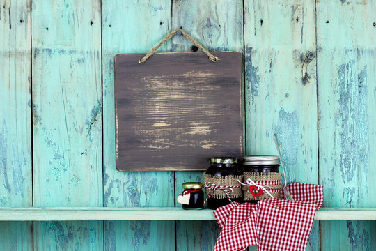 Blank wood sign hanging over jars of homemade jelly