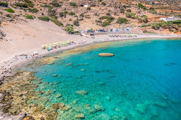 Fototapeta na wymiar Agios Pavlos Beach in Crete island, Greece. Tourists relax and bath in crystal clear water of St. Paul Sandhill Beach.