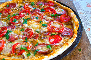 Close up of tasty pizza with chicken, tomato and cheese