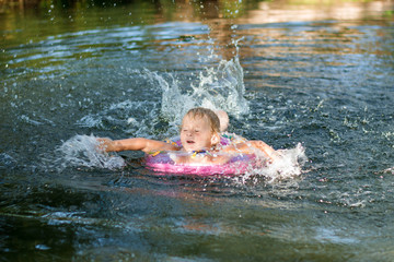 Fototapeta premium little girl floating in the river